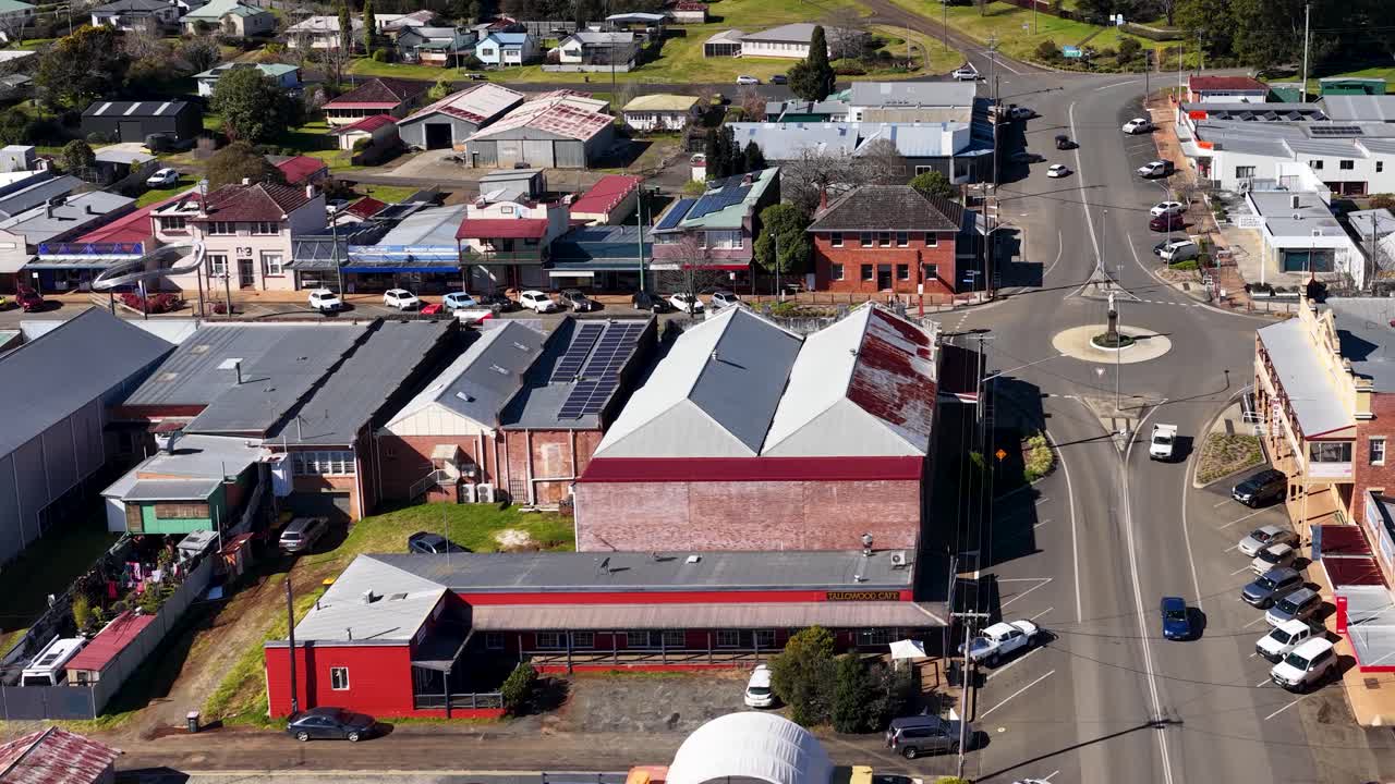 Drone ascends above Dorrigo town center, revealing streets, shops, vehicles, and surrounding rural homes