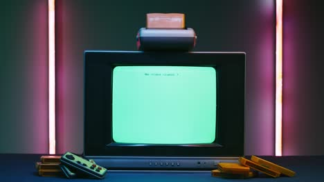 old television with white screen on neon background. close-up of vintage tv and cartridges for retro playstation. antique video game, nostalgia