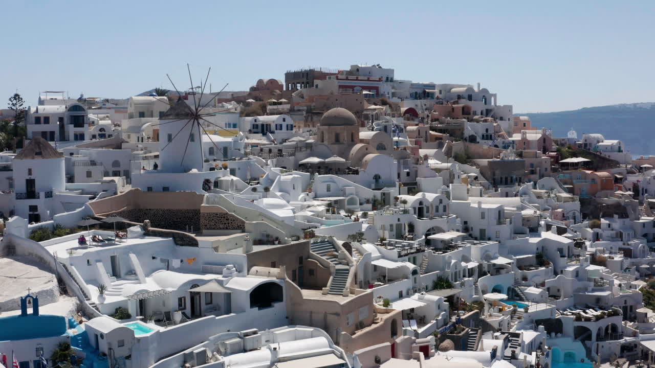 pueblo de oia en grecia - molino de viento de oia con hoteles de lujo y casas típicas pintadas de blanco y azul