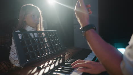 music teacher giving a lesson to a young student on a keyboard