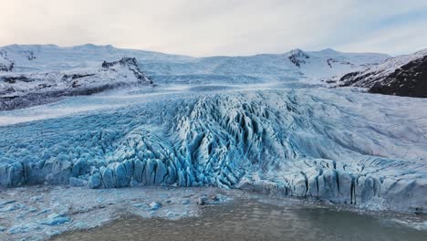 vista aérea de un glaciar con formaciones de hielo con textura, en islandia, al anochecer