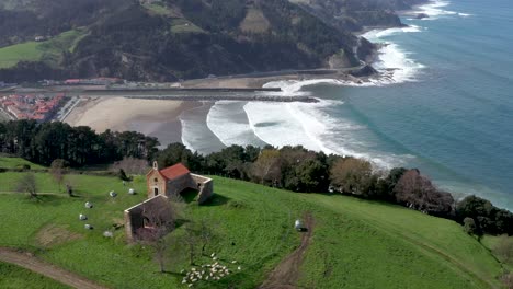 aerial drone view of a hermitage next to the cantabrian sea in deba in the basque country