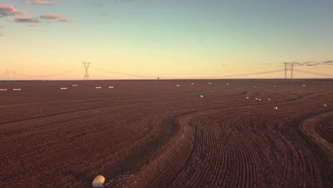 Hermoso-Disparo-De-Un-Dron-Al-Atardecer-Volando-Sobre-Un-Campo-De-Algodón-Recién-Cosechado