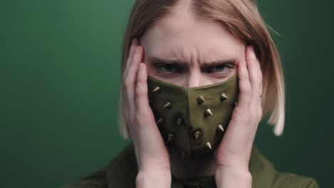 portrait of emotional woman in studded face mask posing