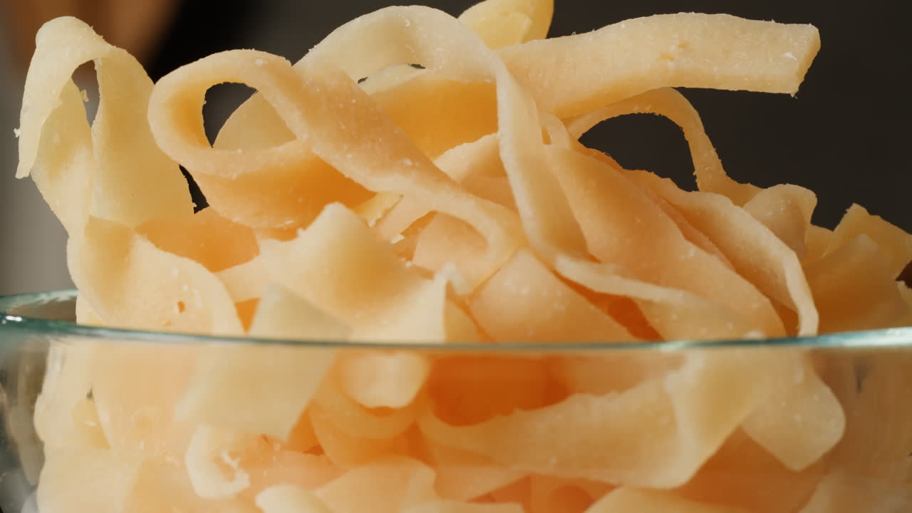 Hand picking dried fish snacks from a bowl