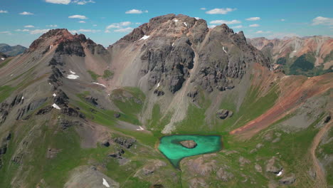 Cinematic-aerial-drone-high-elevation-dreamy-heavenly-Island-Lake-Silverton-Ice-Lake-Basin-unreal-Caribbean-aqua-blue-Silverton-Colorado-lush-green-summer-snow-melting-Rocky-Mountains-slowly-up-jib