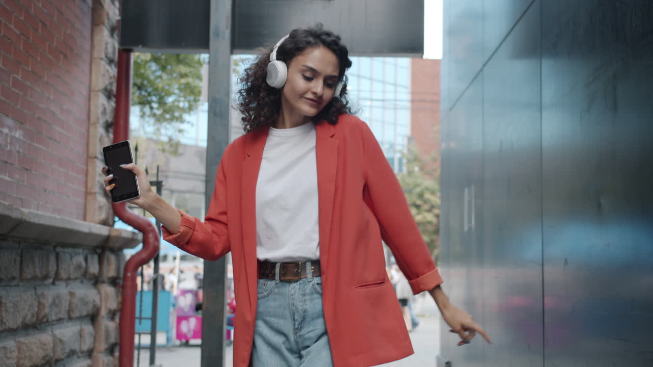 Woman Dancing and Listening to Music in an Urban Alley