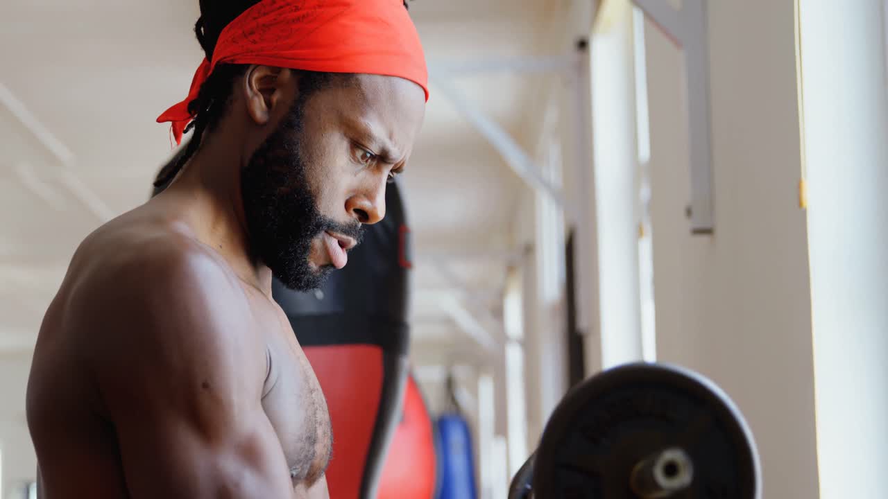 Male boxer exercising with dumbbell in fitness studio 4k