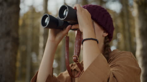 female explorer searching through binoculars