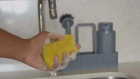 a person washing their hands with soap and water in a kitchen sink