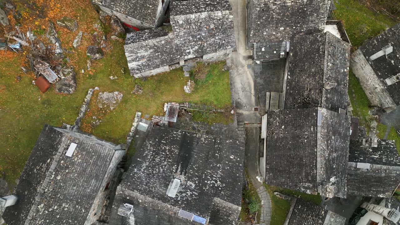 drone aéreo zoom out disparado sobre viejos techos de casas vacías de la aldea en cavergno, distrito de vallemaggia, cantón de ticino en suiza durante el día