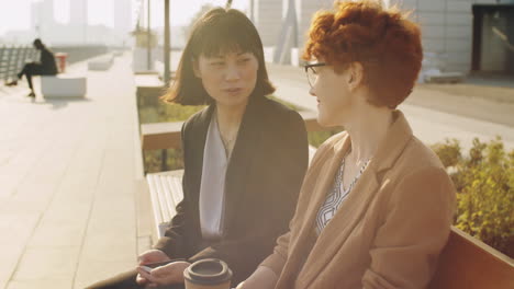 아시아와 백인 사업가 여성들이 거리에서 이야기하고 있습니다.