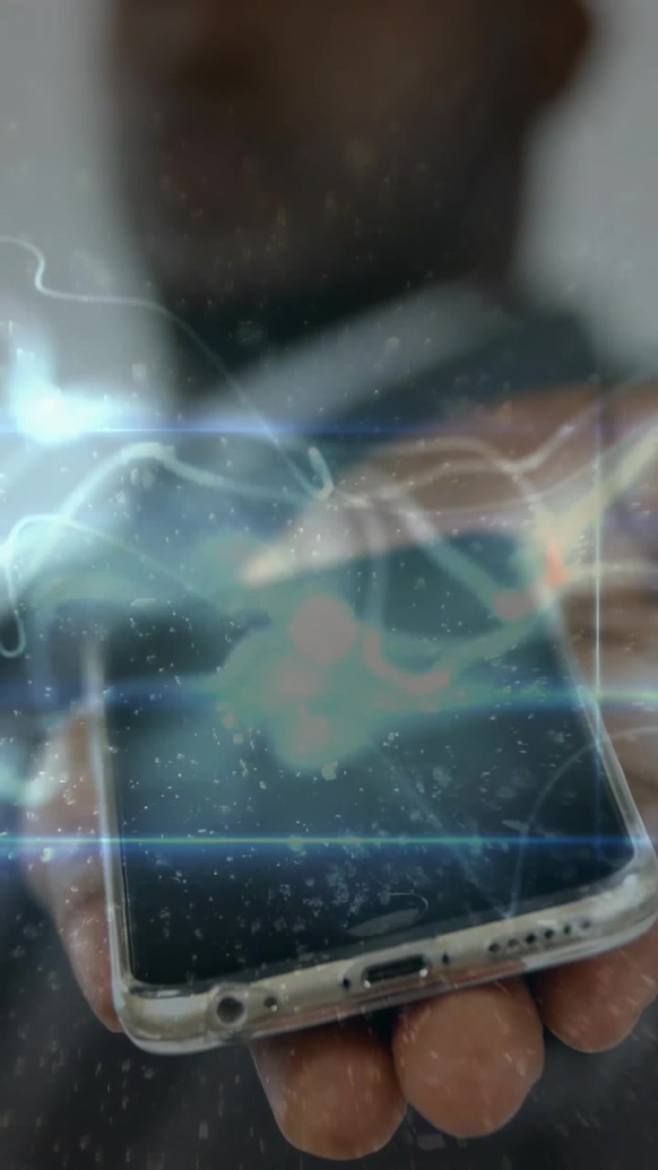 Holding man in suit offering smartphone to camera, studio, clear case, visible ports, blue overlay