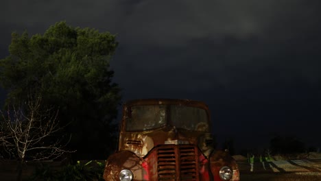 old truck under dark, cloudy sky