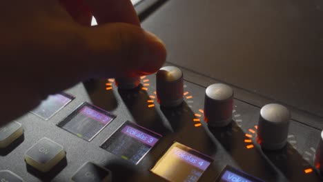 a person turning a few knobs on a music mixer