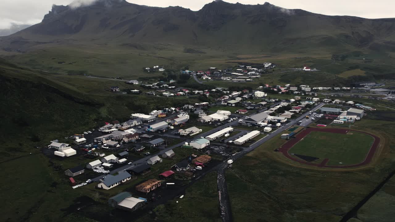 에어리얼 타운 빅, 집 들 과 푸른 잔디 가  ⁇ 인 산 들, 아이슬란드 의 기분 나쁜 구름 이 있는 날