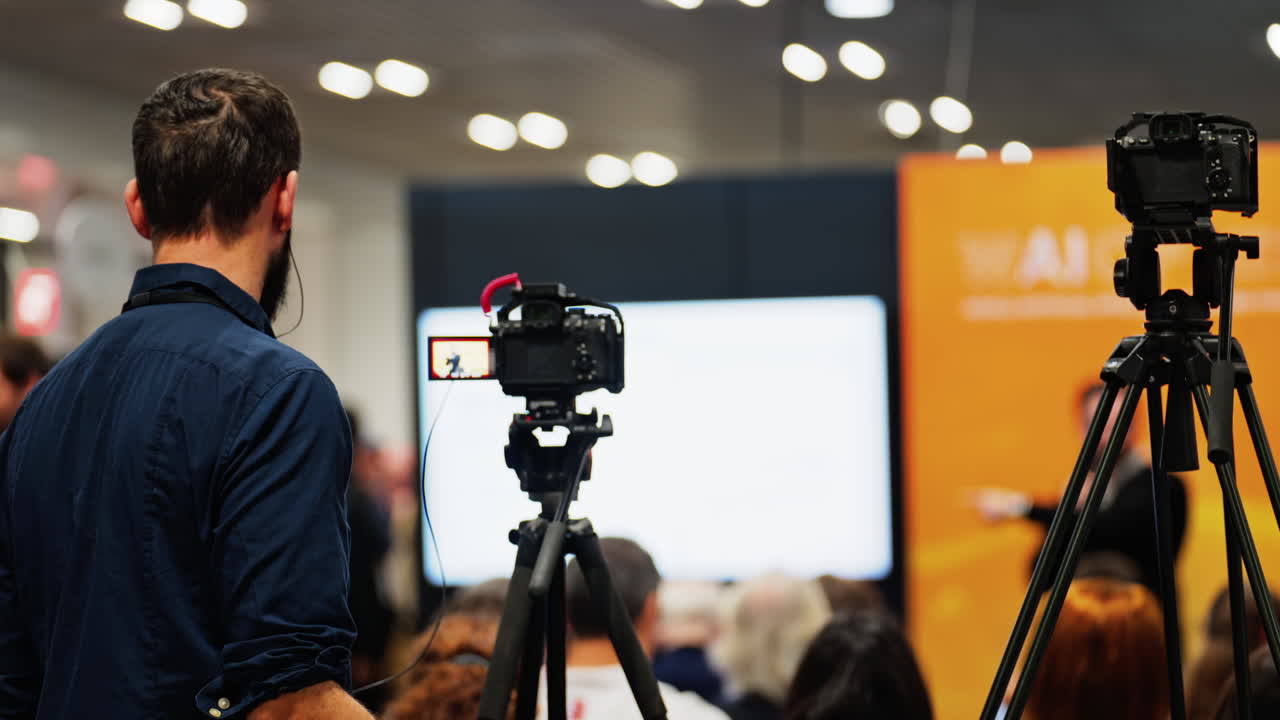 Man filming with a professional camera at a conference