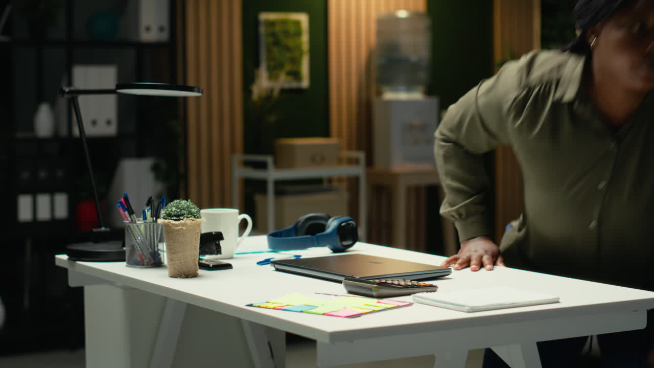 Black business manager closing her laptop after overtime late at night