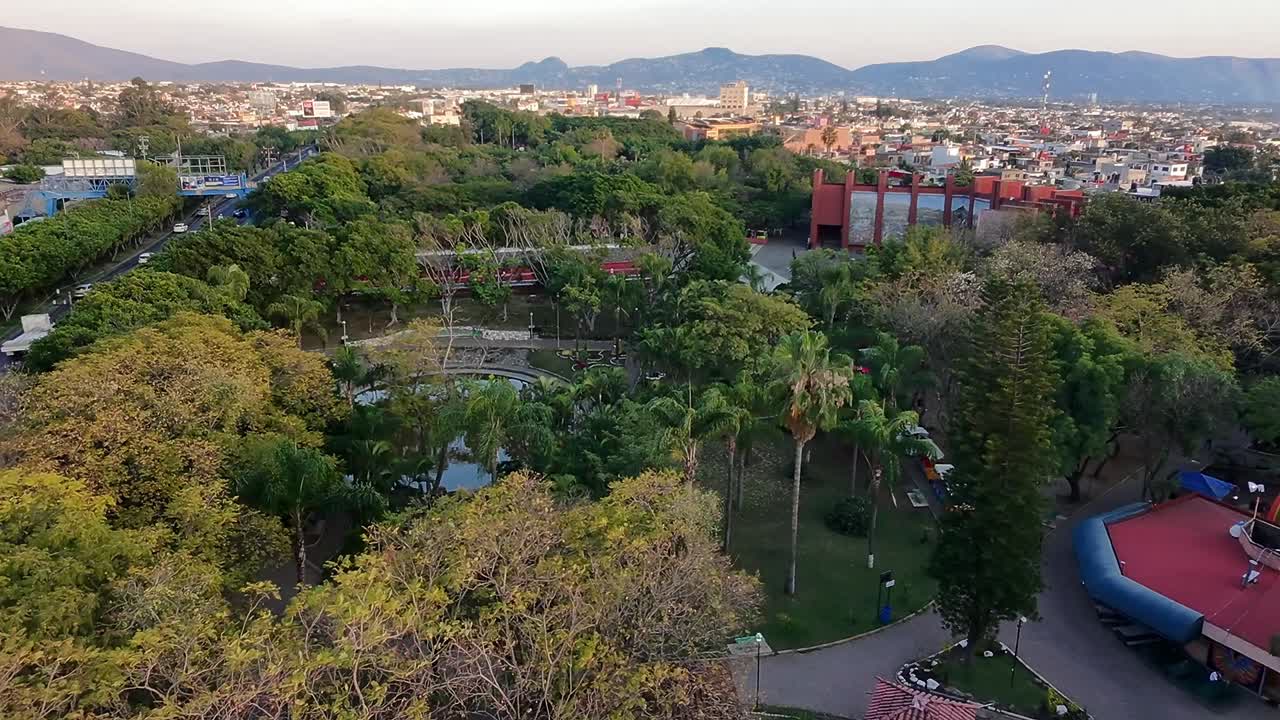 View of Alameda Jiutepec park from above, showcasing lush greenery, walkways, and surrounding cityscape