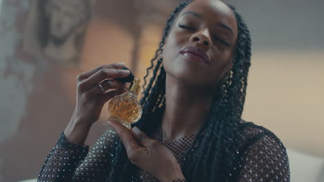 profile view of a african model applying antique perfume on her neck