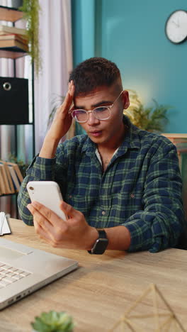 hombre indio triste usa teléfono inteligente sorprendido por malas noticias pérdida de fortuna fracaso lotería resultados de juegos en línea