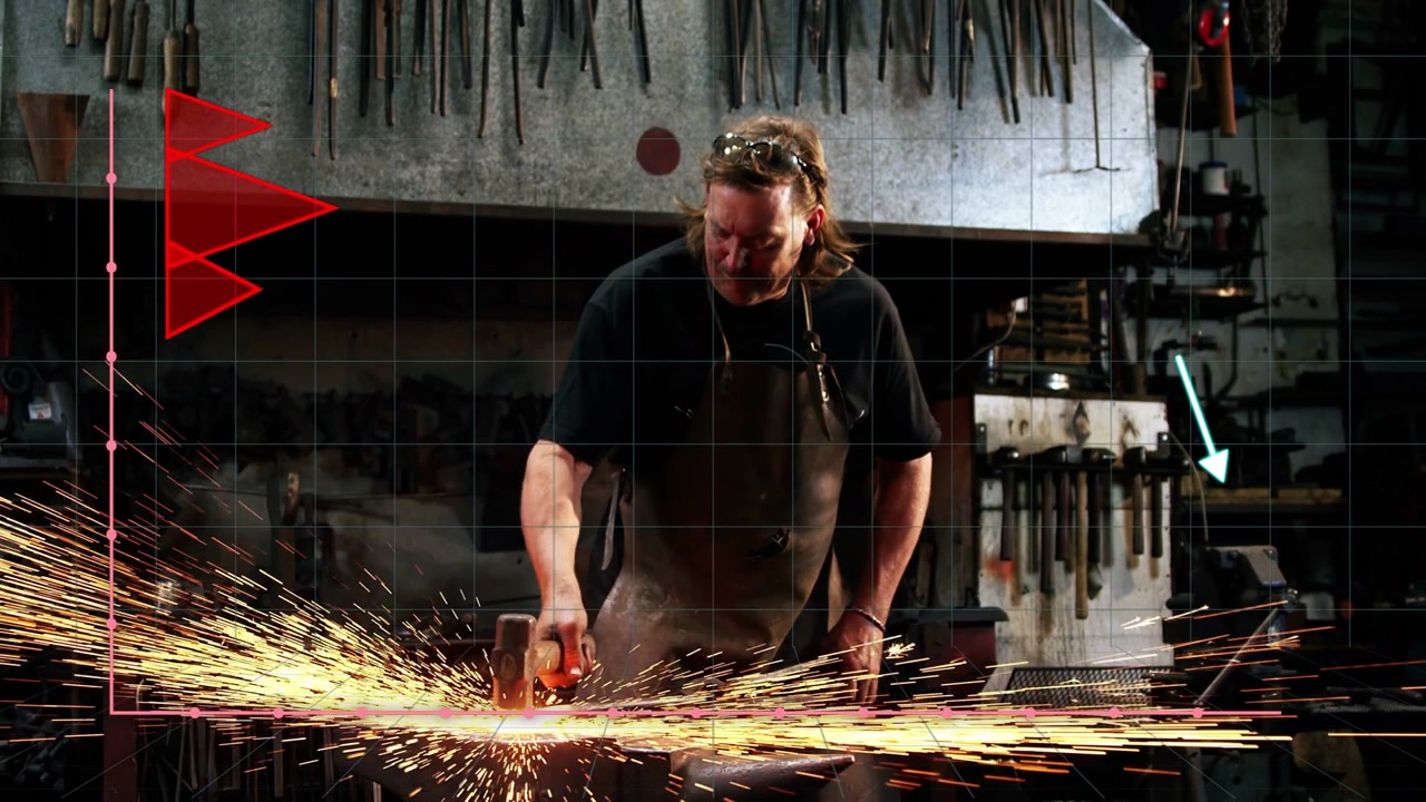 Vertical video: Smith placing hot bar at forge, causing hammering then grind sparks, charts behind