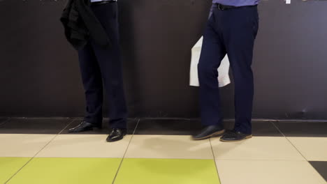 businessmen discussing plans near a dark wall