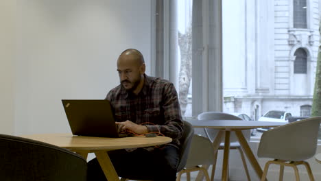 focused male ceo executive manager in suit working on computer, managing tasks on paper checklist in office