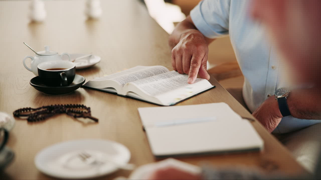 Senior man studying Bible over tea