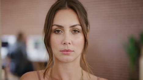 retrato en primer plano de una hermosa mujer joven que mira seriamente a la cámara empresaria independiente en el espacio de trabajo de la oficina