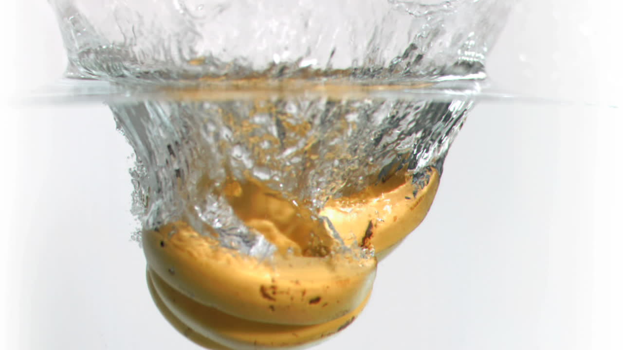 plátanos cayendo en el agua en súper cámara lenta