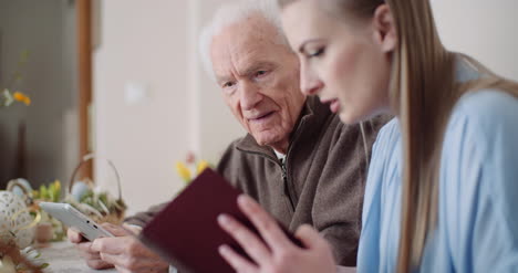 Young-Woman-Surfing-Internet-With-Grandfather-On-Digital-Tablet-4