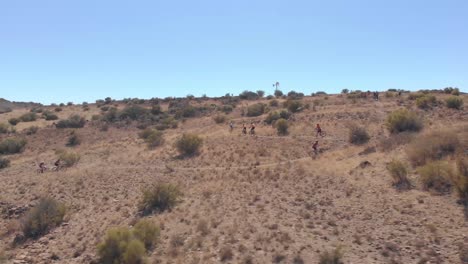 aerial-field-of-mountain-bikers-riding-up-a-single-track