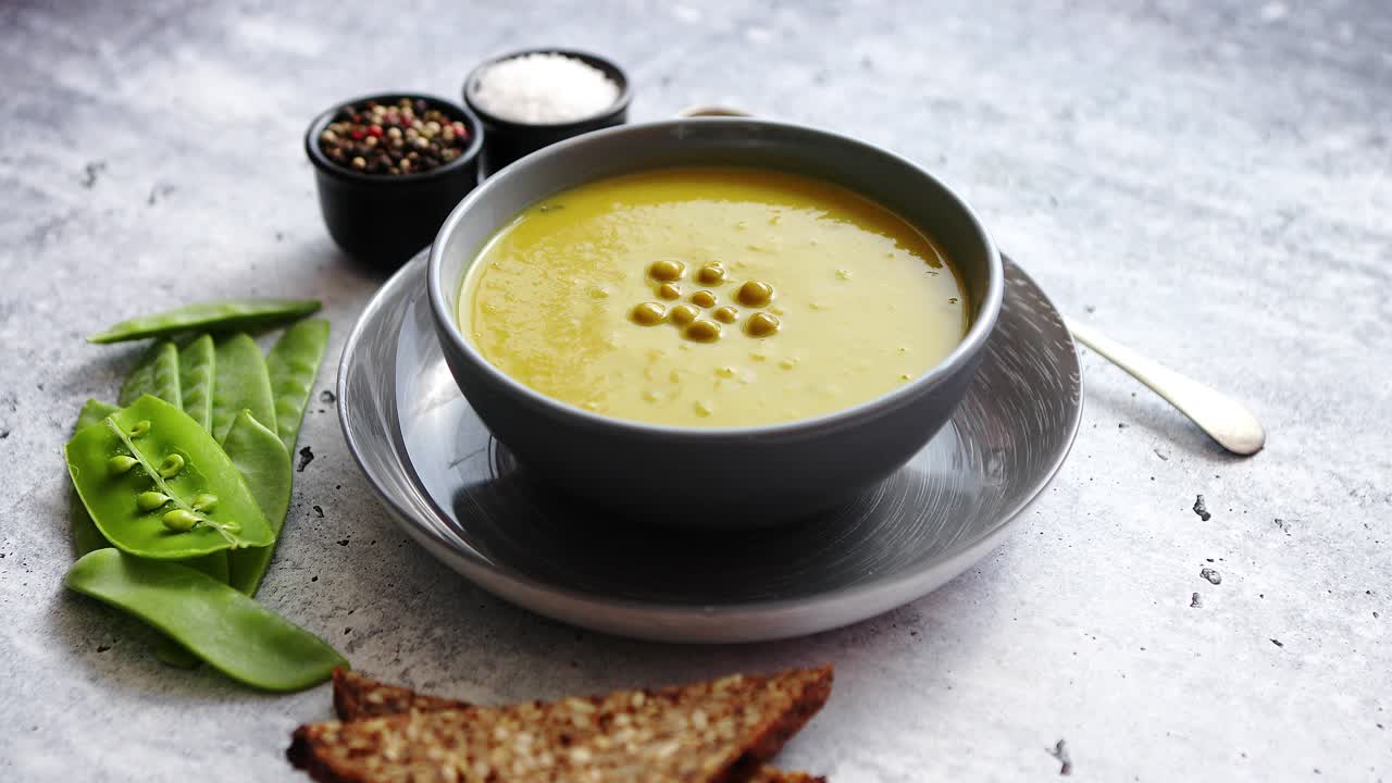 sopa de crema de guisantes verdes en tazón gris