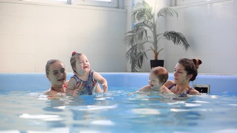 Group-of-mums-with-their-baby-children-at-infant-swimming-class