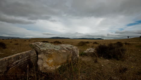 cloudscape time-lapse with large boulders in the foreground