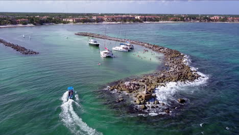 aerial fly down to reveal party boats in cove