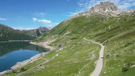 rv motorhome drives along mountain lake lac de grand maison in french alps - aerial