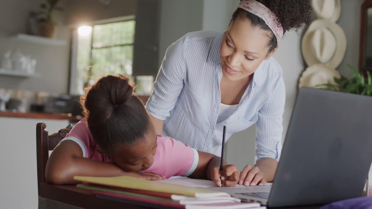 madre y hija afroamericanas felices usando portátil, haciendo la tarea, cámara lenta, sin alteración.