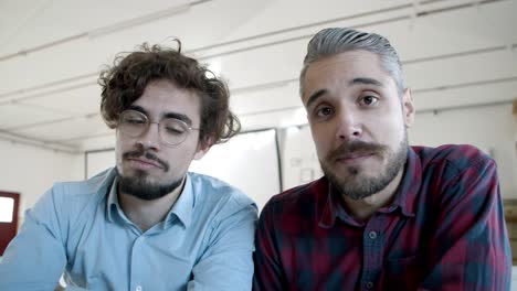 smiling men having video call through laptop