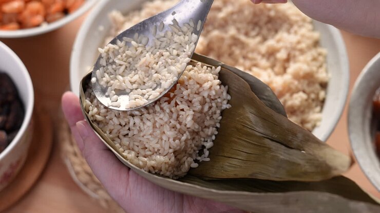 Making zongzi food - preparing and wrapping Chinese rice dumpling.