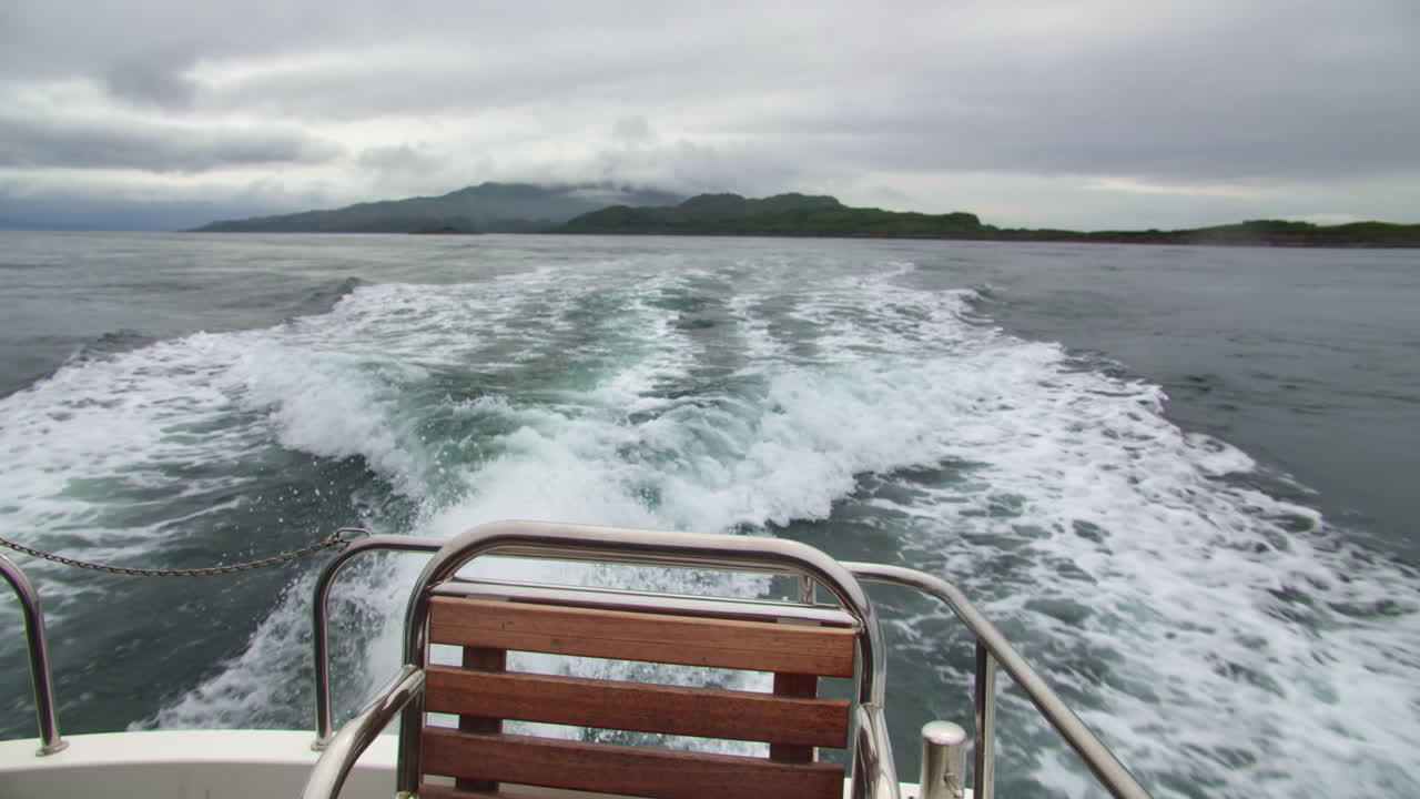 Blick auf Inseln mit Kielwasser von einem Boot während einer Schottlandreise in Europa