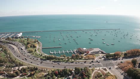 Chicago,-Illinois-with-Lake-Michigan-and-cars-driving-on-Lakeshore-Drive-with-stable-drone-video