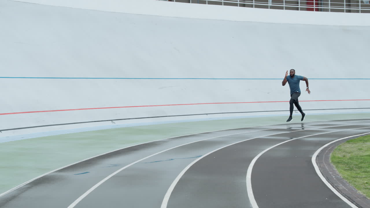 스포츠 의류 를 입은 남자 가 경주장 에서 조 하고 있다