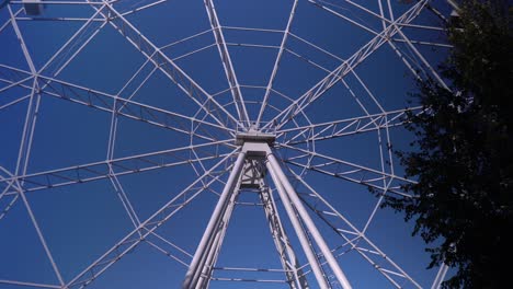 in the park, a large ferris wheel is spinning slowly. high-altitude view wheel