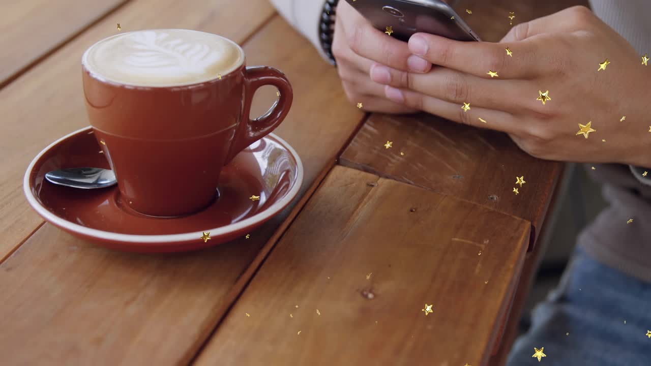 Male patron tapping smartphone beside latte cup, scrolling messages while gold sparkles drifting
