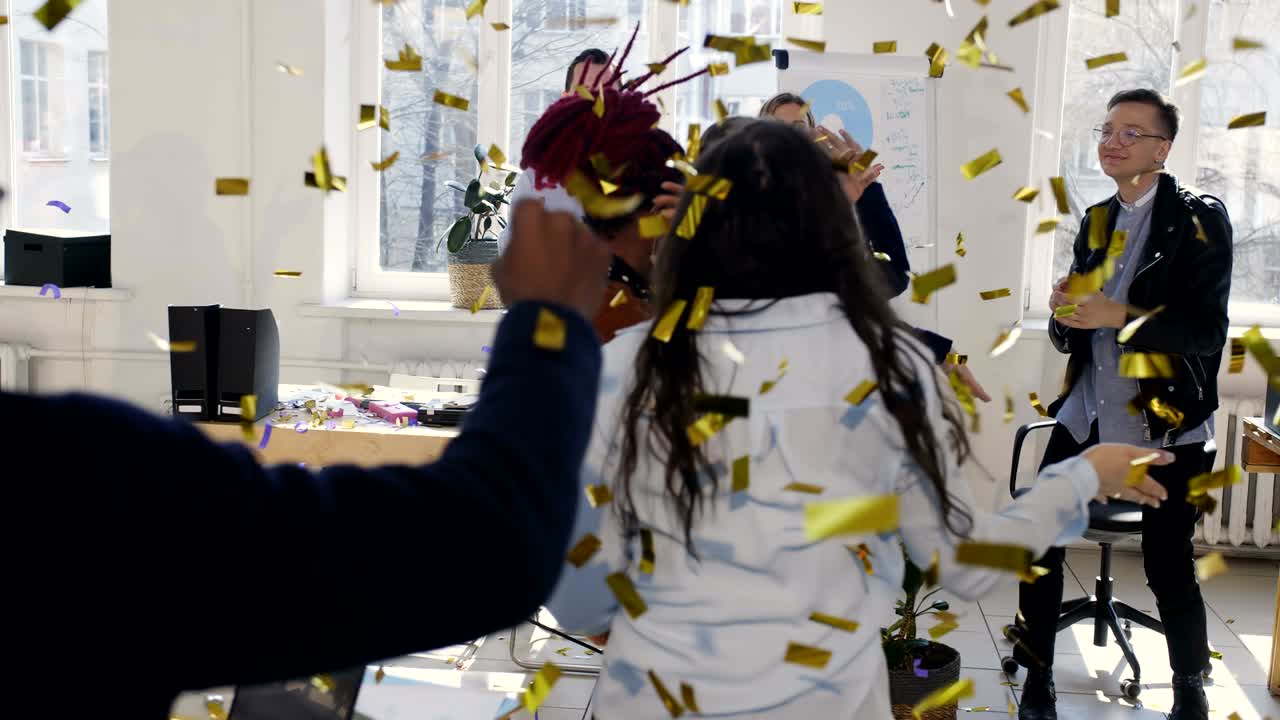 Healthy multiethnic workplace. Fun happy diverse business women doing celebration confetti dance at office workplace.