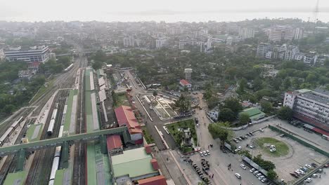 city landscape with train station, streets, park and buildings around under a dusty sky