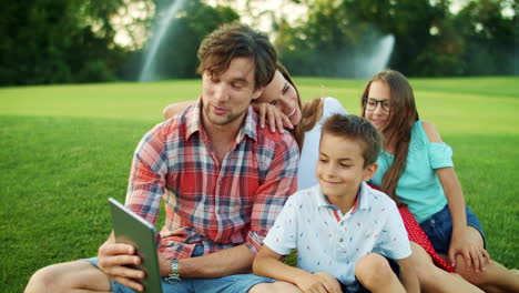 family calling on web camera with tablet outdoors