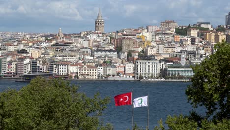 flag of turkey blowing in the wind, galata tower in the background, istanbul, turkey